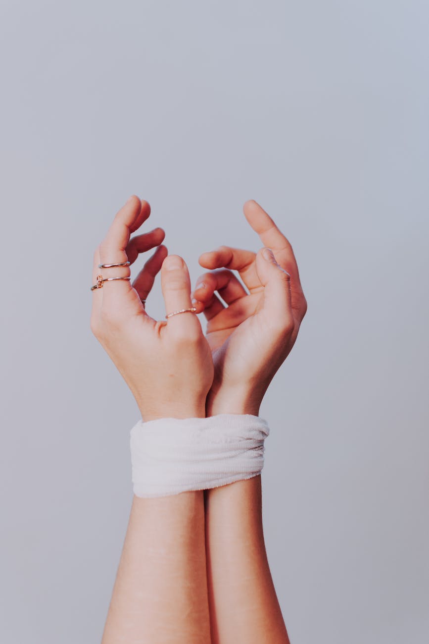 anonymous woman with tied hands against gray background